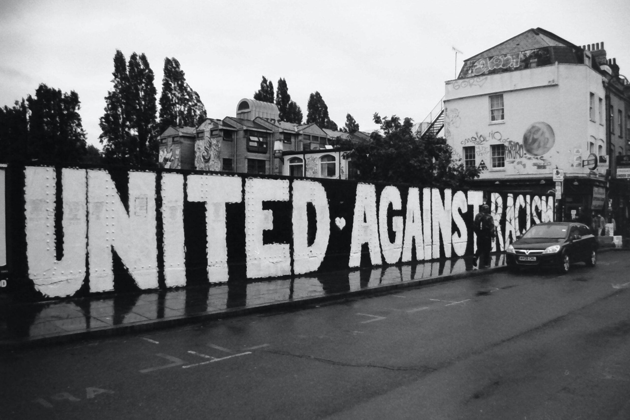 Monochrome Shot of a Graffiti Against Racism