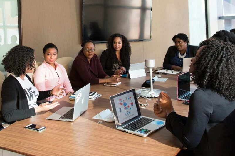 8 people sit around a conference table in discussion