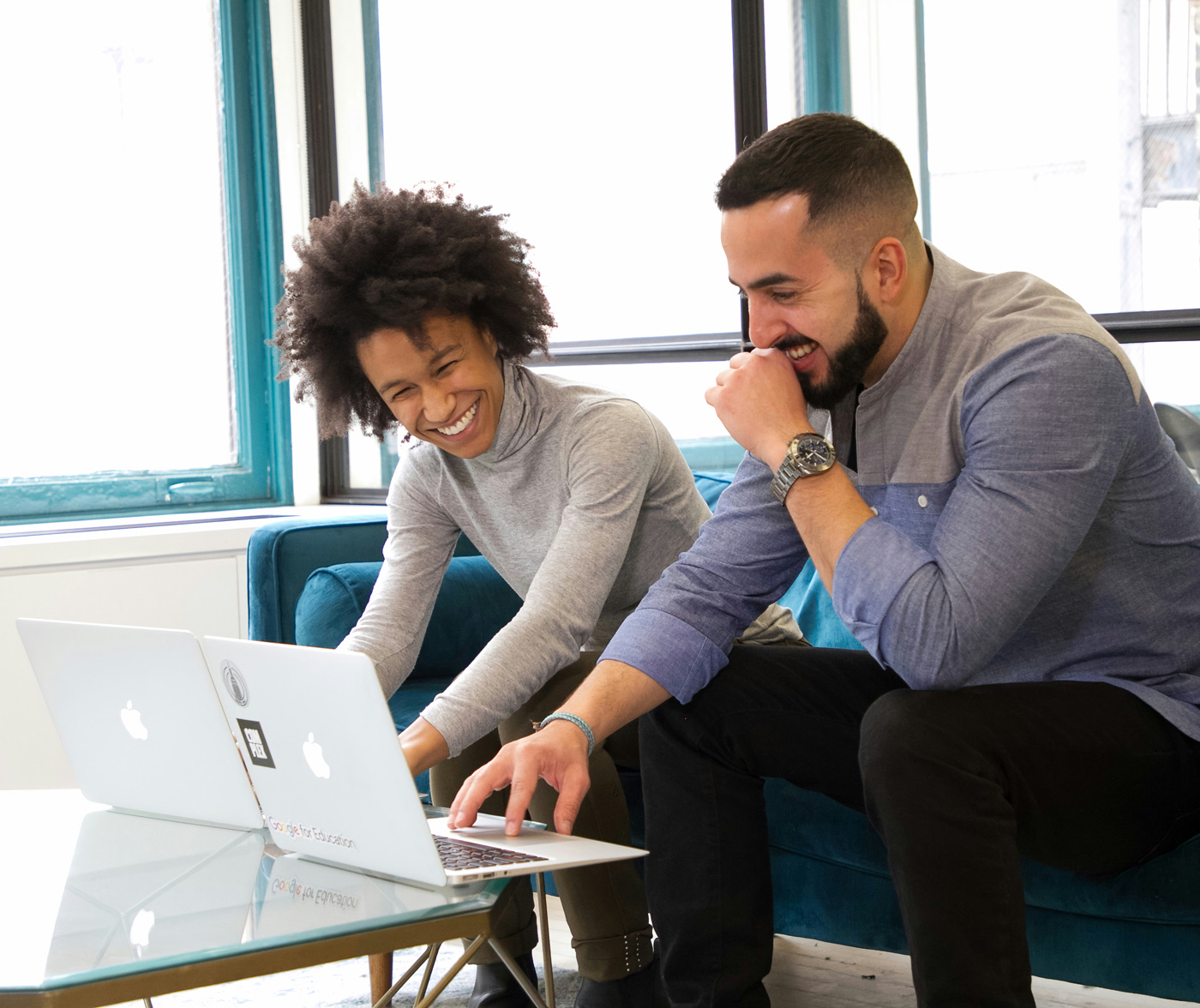 Image of smiling man and woman working together on laptops